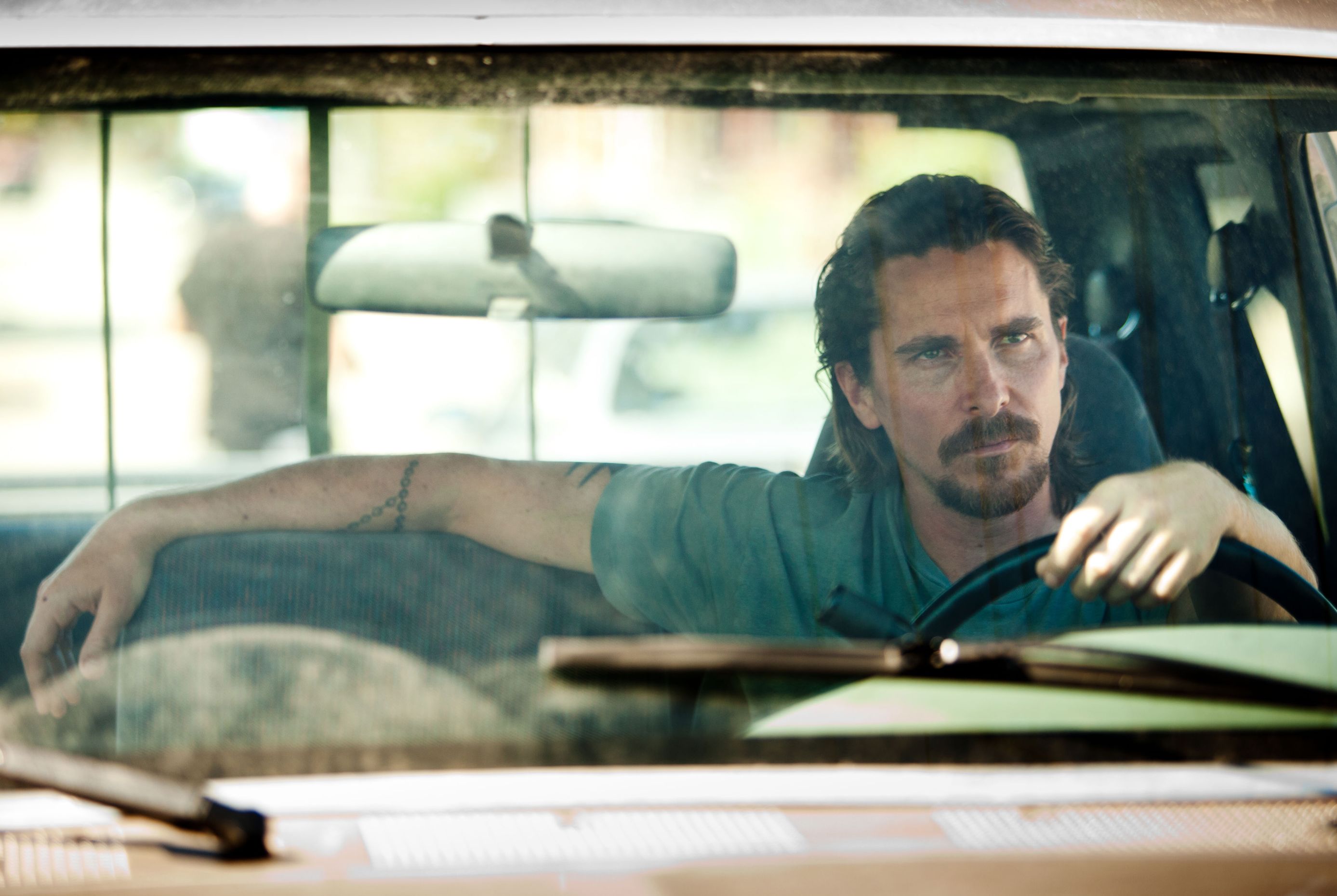 Chistian Bale looking entertained inside old car