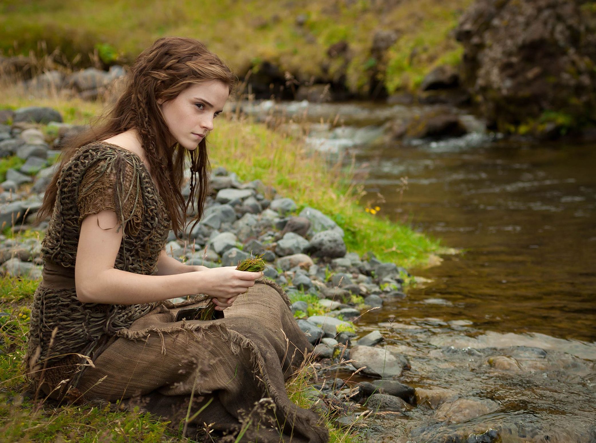 Emma Watson as Ila sitting by the water in Noah