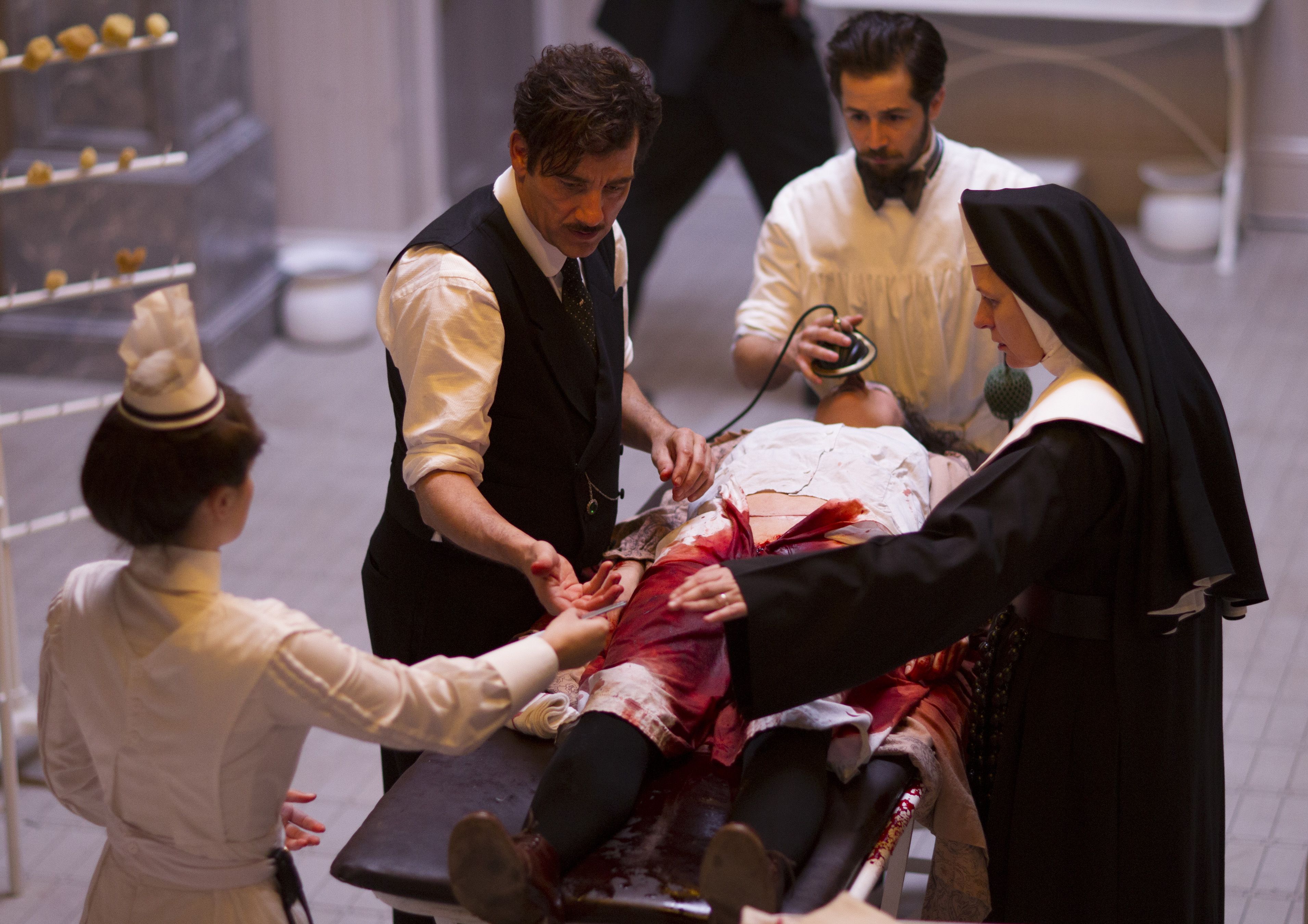 Clive Owen, Michael Angarano, a nurse and a nun operate on a