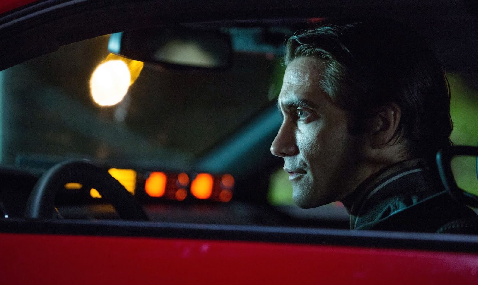 Jake Gyllenhaal watching from his cherry red Challenger in N
