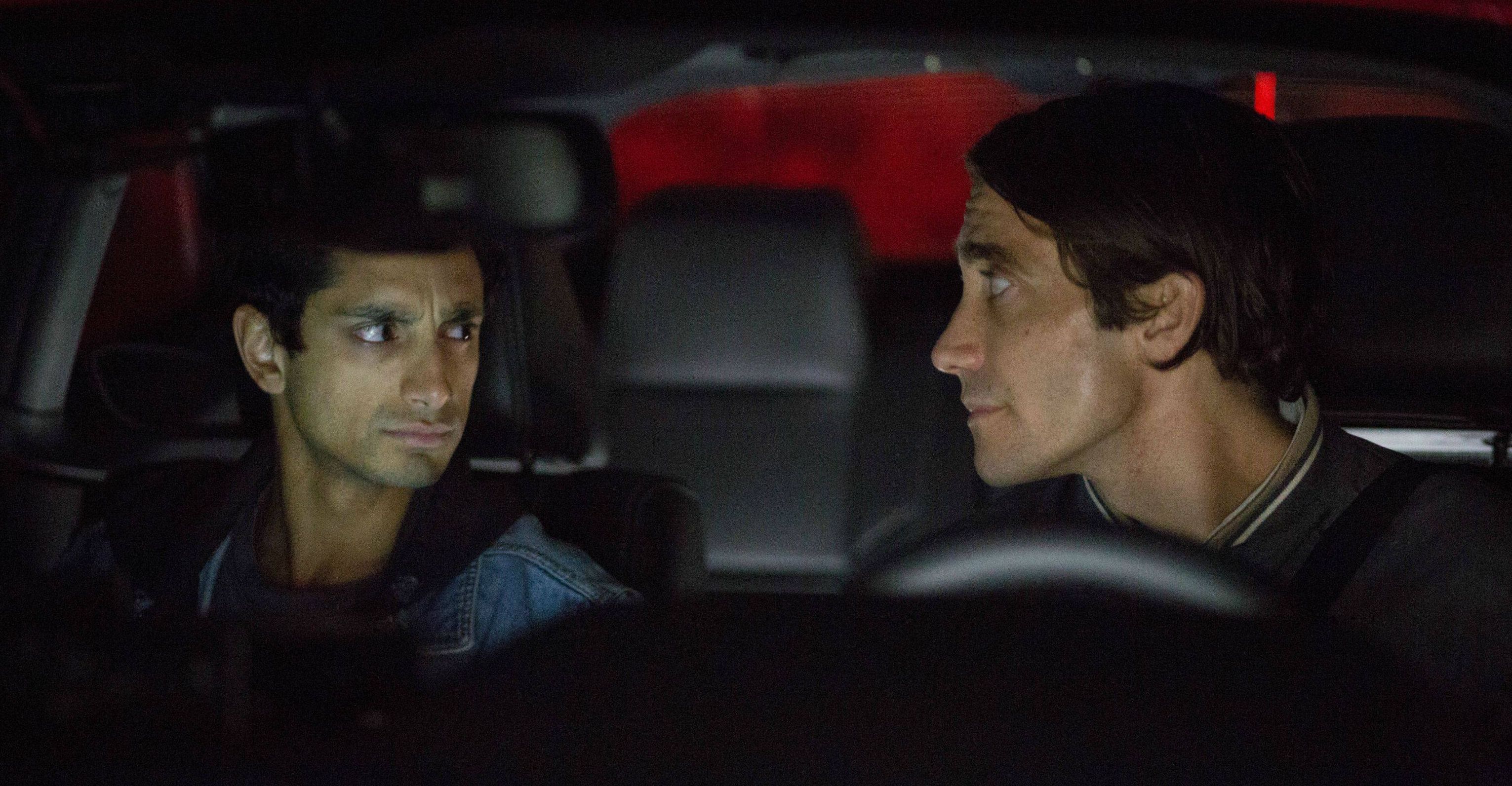 Riz Ahmed frowning at Jake Gyllenhaal in Nightcrawler