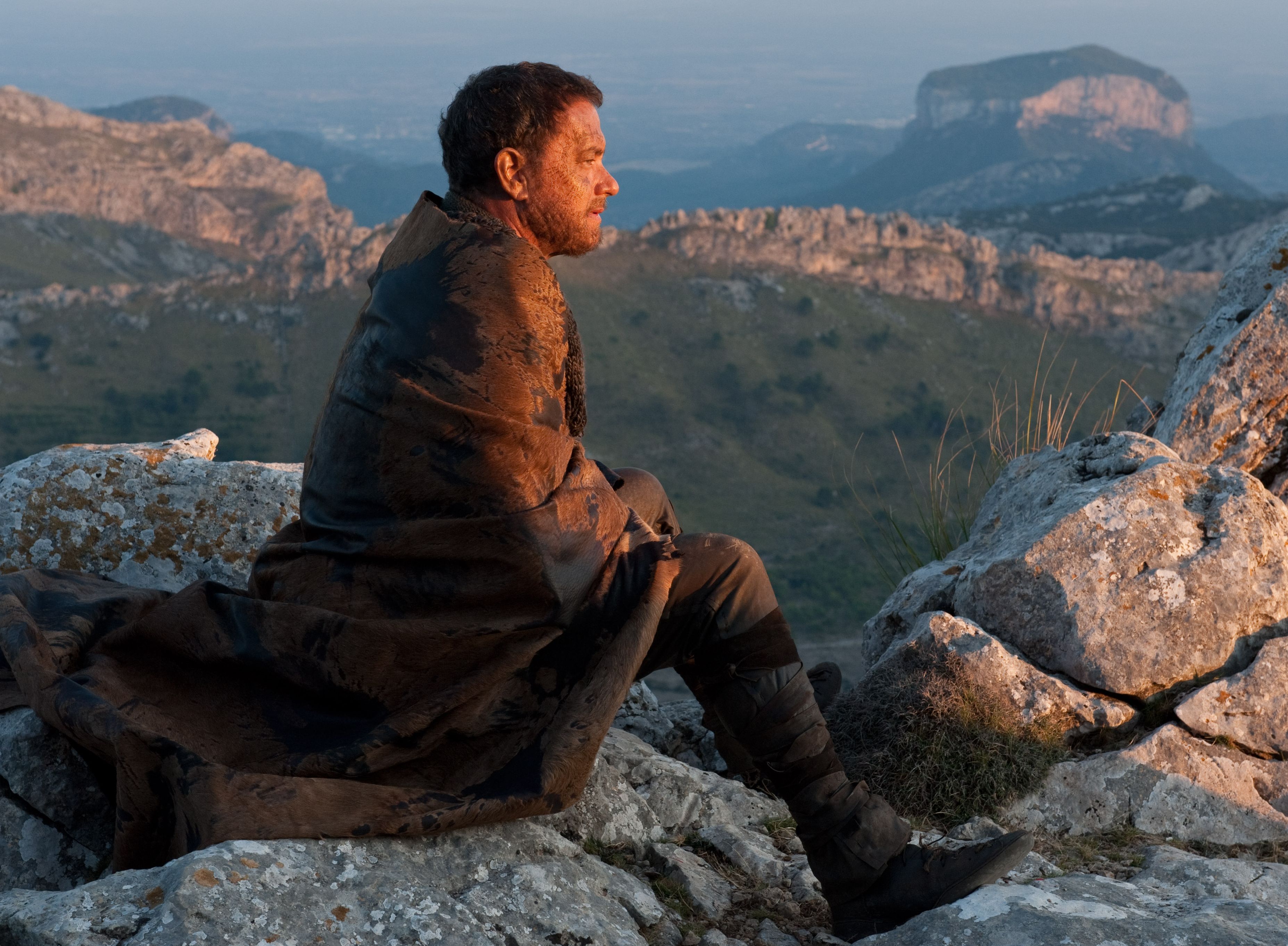 Tom Hanks looks down from a mountain in Cloud Atlas