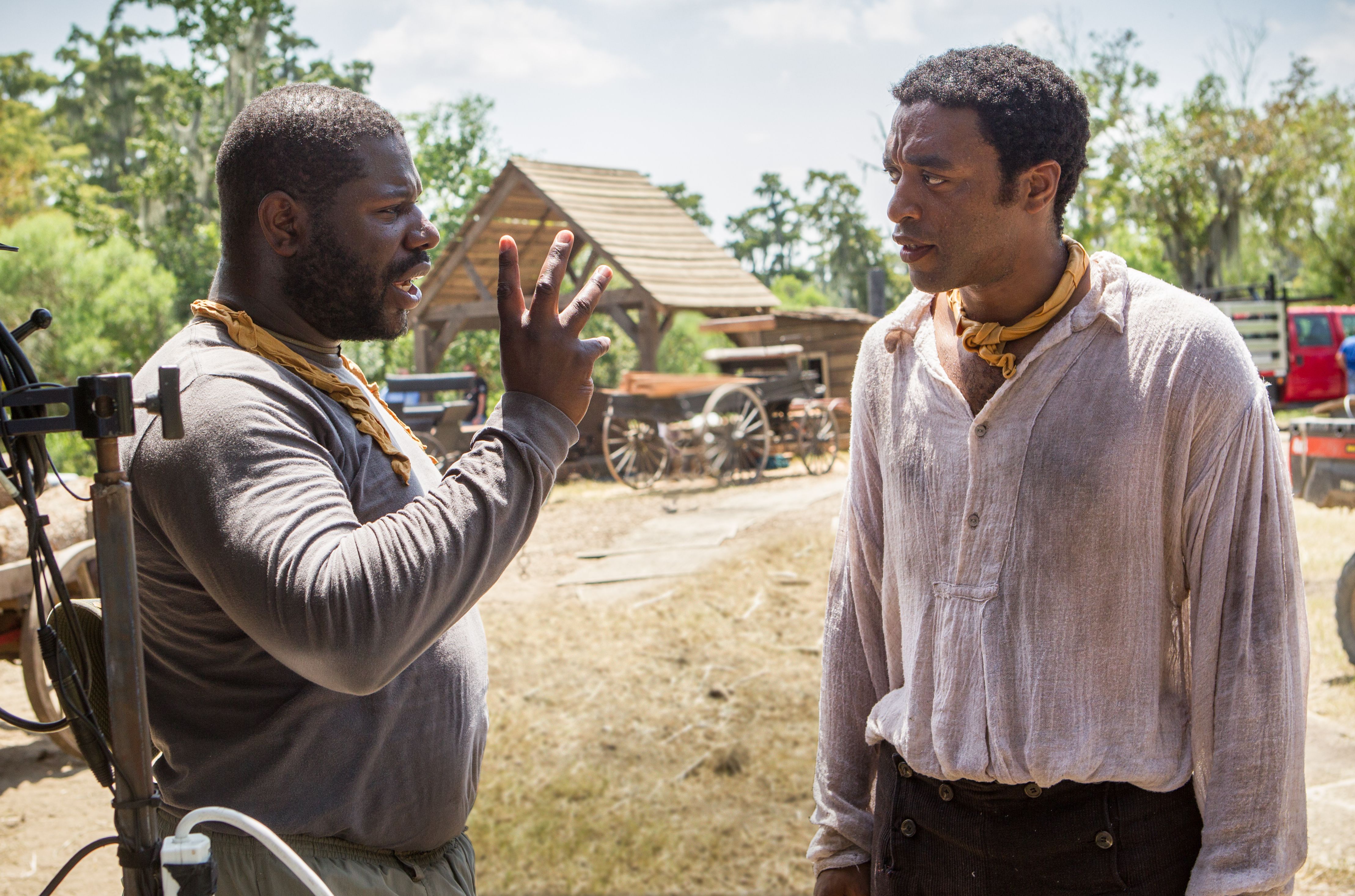 Director Steve McQueen and Chiwetel Ejiofor discuss a scene 